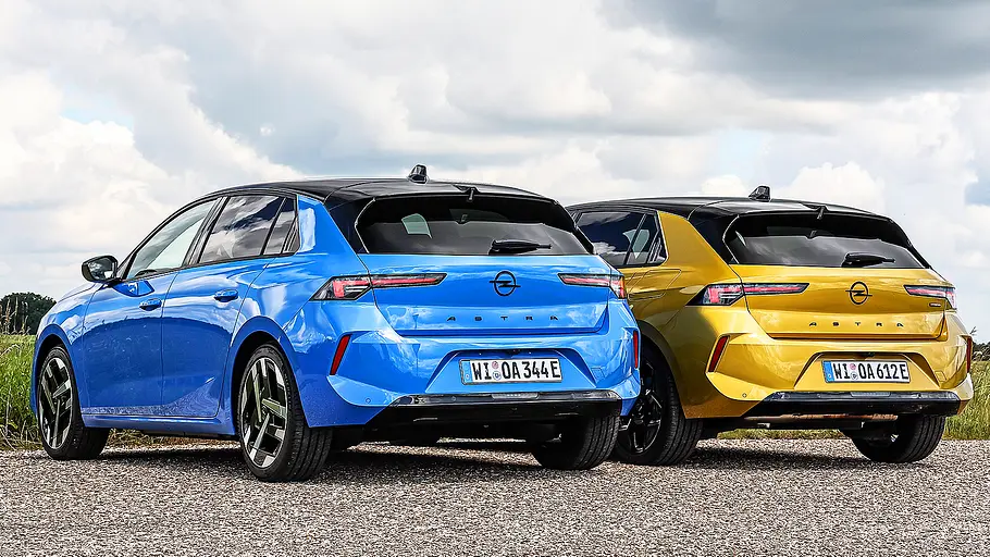 Blick von schräg hinten auf die beiden fahrenden Kompakten Opel Astra Electric und Opel Astra Plug-in-Hybrid.