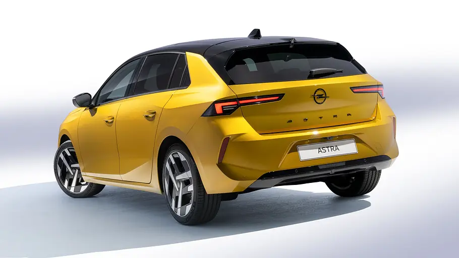 Opel Astra Facelift Das Opel Astra Facelift fahrend von schräg hinten fotografiert.