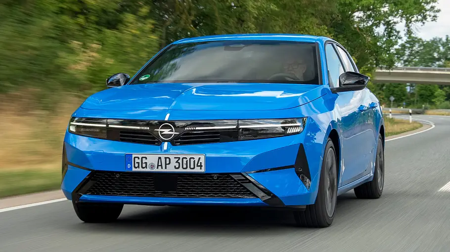 Opel Astra Facelift Das Opel Astra Facelift fährt auf einer Landstraße, von vorne fotografiert.