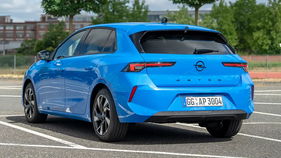 Opel Astra Facelift Das Opel Astra Facelift steht auf einem Parklplatz, von hinten fotografiert.