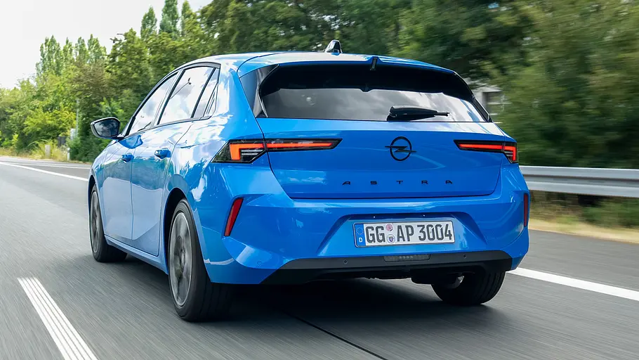 Opel Astra Facelift Das Opel Astra Facelift fährt auf einer Landstraße, von hinten fotografiert.