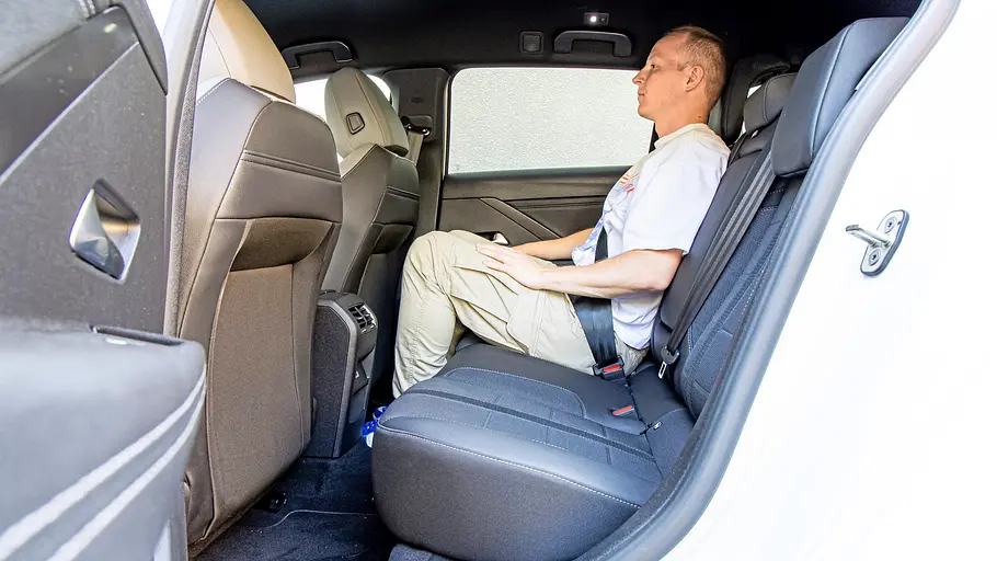 Blick durch die geöffnete linke Hintertüre auf die Rückbank des Opel Astra Sports Tourer, auf der eine Person sitzt.