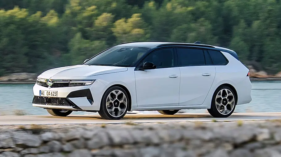 Opel Astra Sports Tourer Facelift fahrend auf einem Damm, von der linken Seite fotografiert.