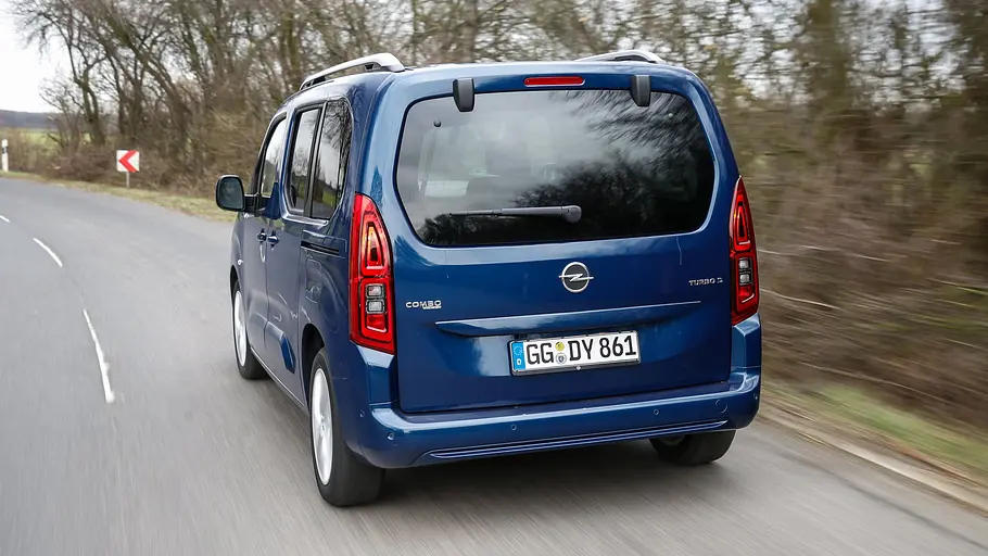 Der Opel Combo (2018) fährt eine Landstraße entlang, von hinten links fotografiert.