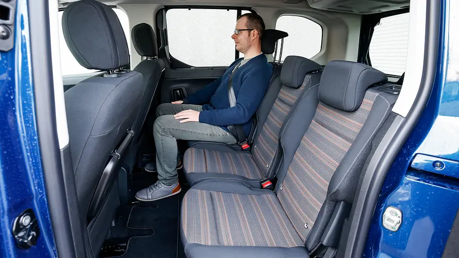 Ein Mann sitzt im Fond des Opel Combo (2018).