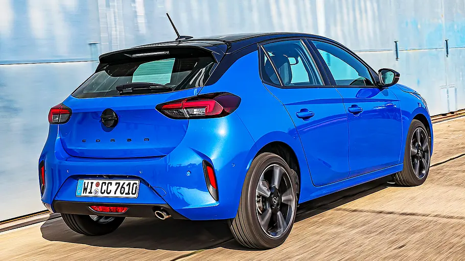 Blick von schräg hinten auf den fahrenden Opel Corsa.