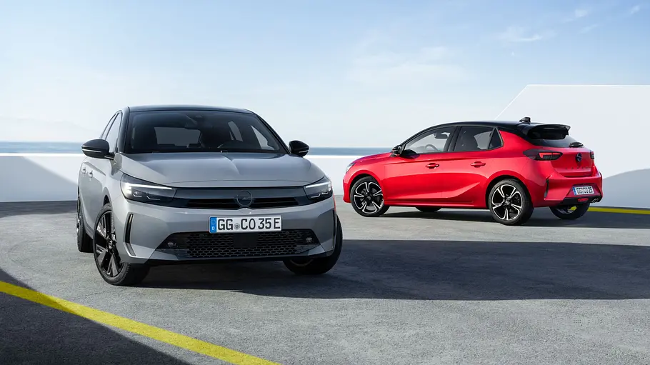 Opel Corsa Leasing-Angebote Zwei statische Opel Corsa vor einer weißen Wand. Links in Grau ist der Opel Corsa Electric von schräg vorne rechts, rechts der Opel Corsa Hybrid in Rot von schräg hinten links.