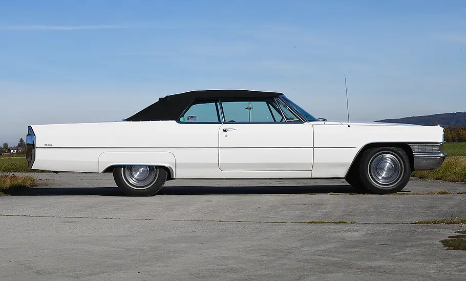 Der Cadillac De Ville Convertible stehend von der Seite fotografiert. Das Verdeck ist geschlossen.