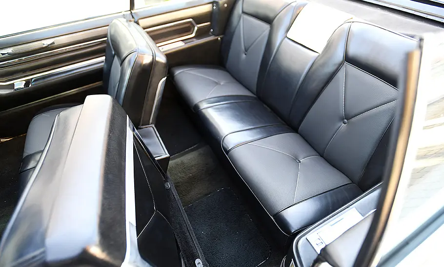 Cadillac De Ville Convertible Blick in den Innenraum des Cadillac De Ville Convertible mit geöffnetem Verdeck, der Fokus liegt auf der zweiten Sitzreihe.