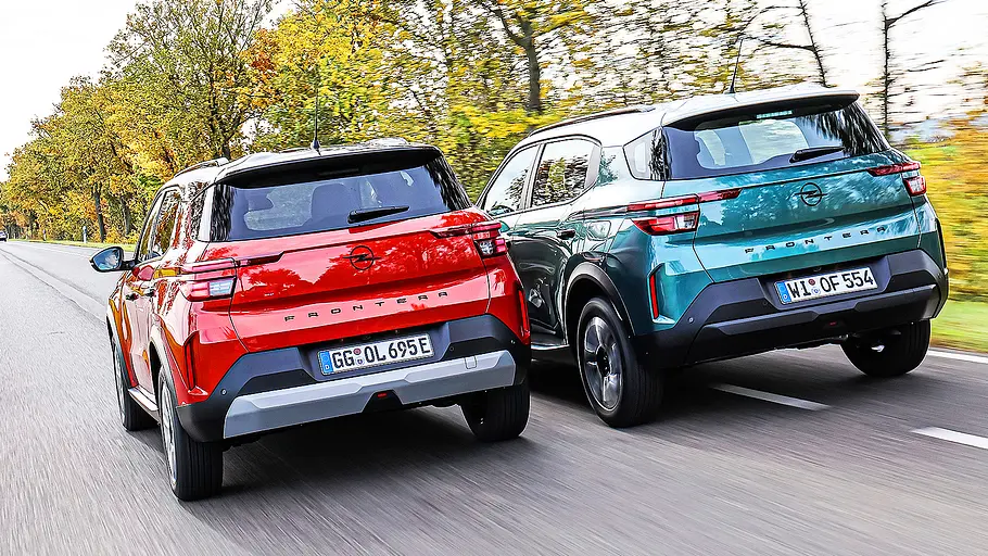 Blick von schräg hinten auf die beiden Opel Frontera – Electric und Benziner.