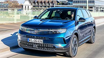 Blick von schräg vorne auf den fahrenden Opel Grandland Hybrid 48 V. - Foto: Frank Ratering