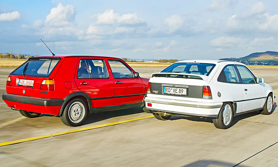 VW Golf GTI 16V/Opel Kadett E GSi 16V fahrend von schräg hinten fotografiert.