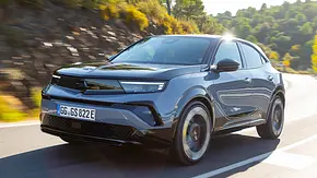 Der Opel Mokka GSE fährt durch eine Rechtskurve, fotografiert von schräg vorne links. - Foto: Opel