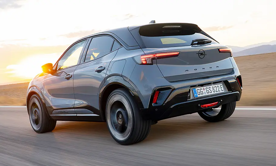 Der Opel Mokka GSE fährt geradeaus, fotografiert von schräg hinten links.