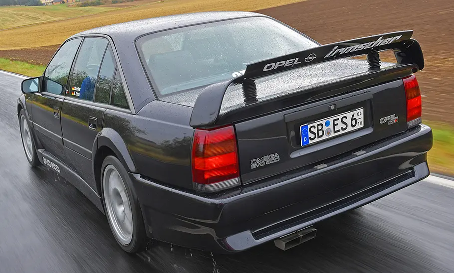 Der Opel Omega Evo 500 fahrend von schräg hinten.