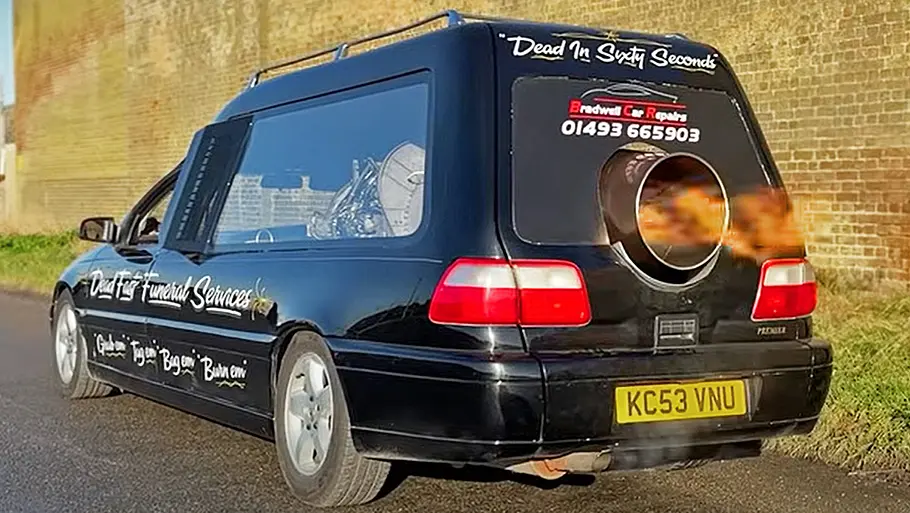 Der Opel Omega Leichenwagen stehend von schräg hinten. Aus der Turbine am Heck schlagen Flammen.