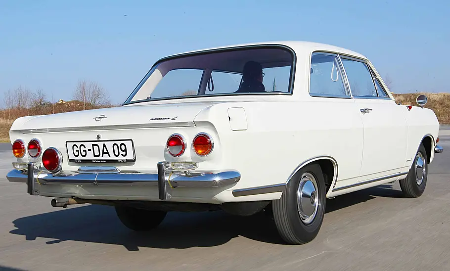 Opel Rekord B fahrend von schräg hinten fotografiert.