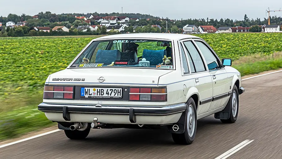 Opel Senator A 2.8 S fahrend von schräg hinten fotografiert. 