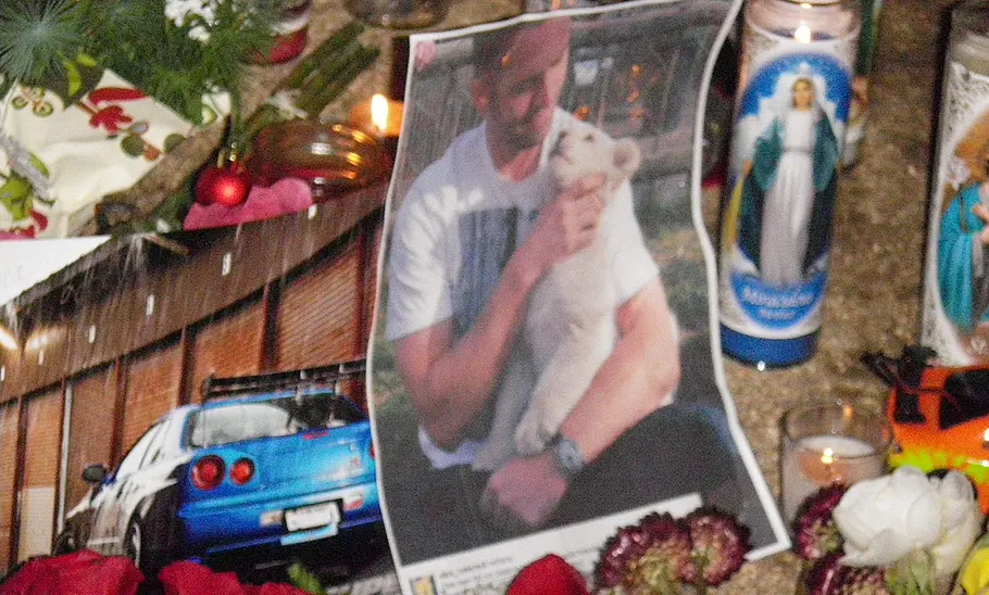 Paul Walkers Unfalltod Paul Walkers Unfalltod: Foto zeigt von Fans errichtete Gedenkstätte am Unfallort, zu sehen sind ein Bild von Paul Walker und Kerzen.