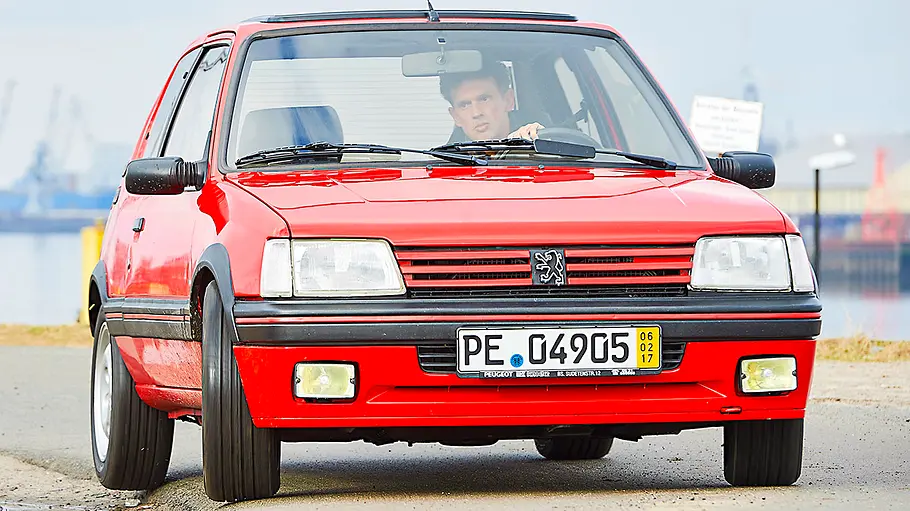 Der Peugeot 205 GTi fahrend von schräg vorne fotografiert.