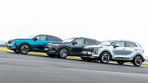 Blick von der Seite auf die drei fahrenden Kompakt-SUV Peugeot 3008, VW Tiguan und Kia Sportage. - Foto: Frank Ratering
