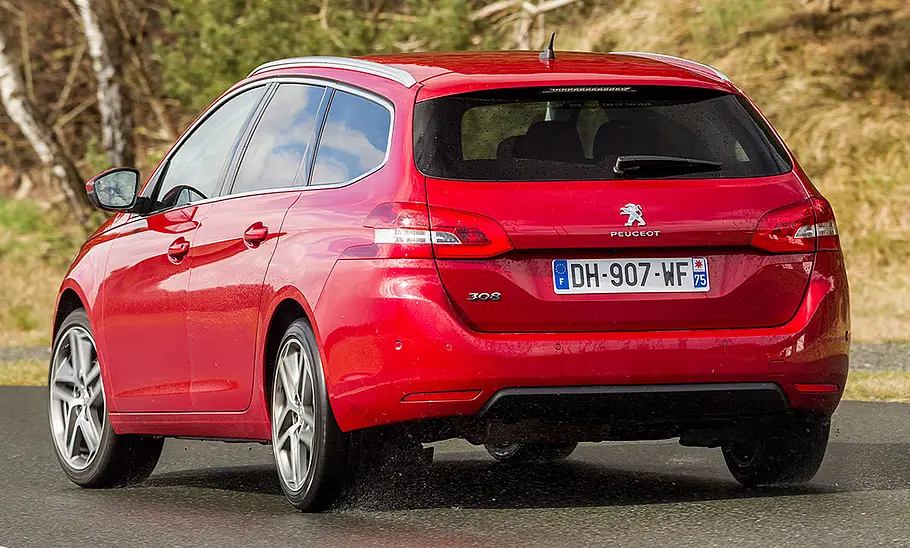 Der Peugeot 308 SW fährt durch eine Kurve, fotografiert von hinten.