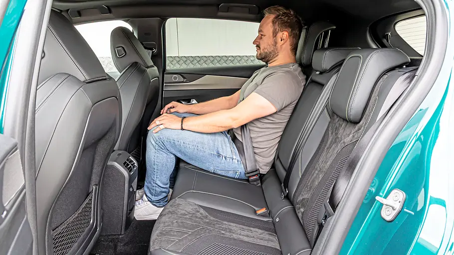 Ein Mann sitzt auf der Rückbank des Peugeot 308 und verdeutlicht die Beinfreiheit im Fond.