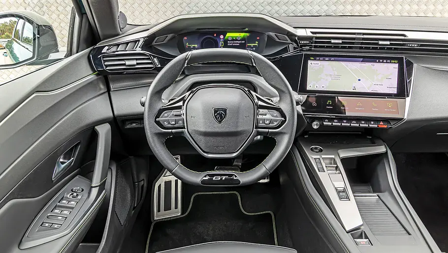 Das Cockpit des Peugeot 308 zeigt ein kleines Lenkrad, digitale Instrumente, einen Navigationsbildschirm und eine breite Mittelkonsole.