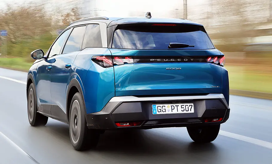 Peugeot 5008 Hybrid (2024) Der Peugeot 5008 Hybrid (2024) fahrend von schräg hinten fotografiert.