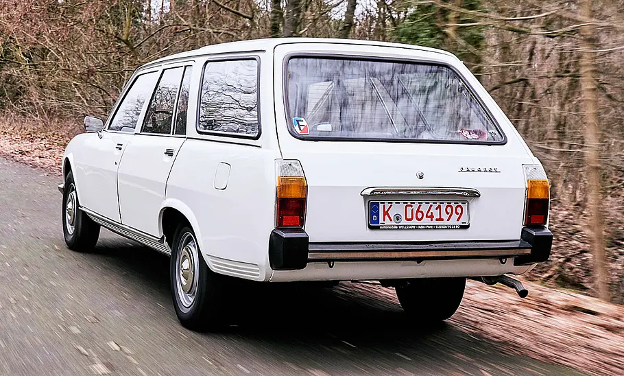 Der Peugeot 504 Commerciale fahrend von schräg hinten