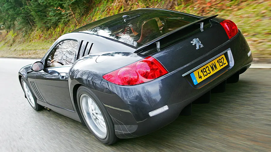 Der Peugeot 907 fahrend von schräg hinten.