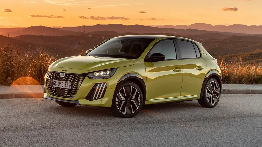 Peugeot e-208 Leasing-News Peugeot e-208 statisch von schräg vorne links auf einem Plateau mit weiter Sicht über hügeliges Land im Sonnenuntergang.