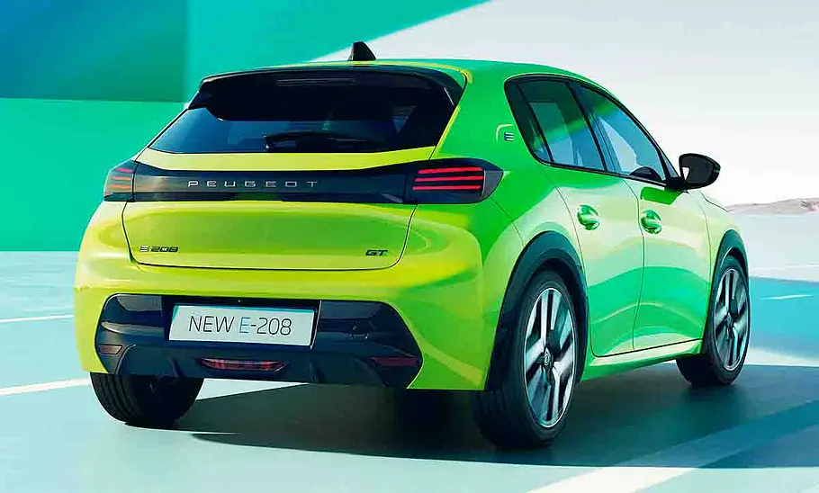 Das Peugeot E-208 Facelift (2023) fahrend von schräg hinten.