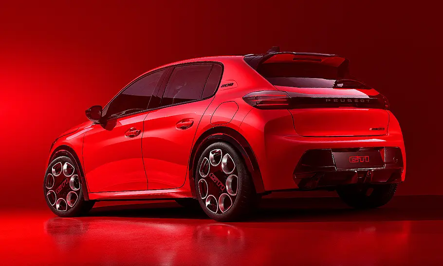 Blick von schräg hinten auf den Peugeot E-208 GTi in rotem Licht.