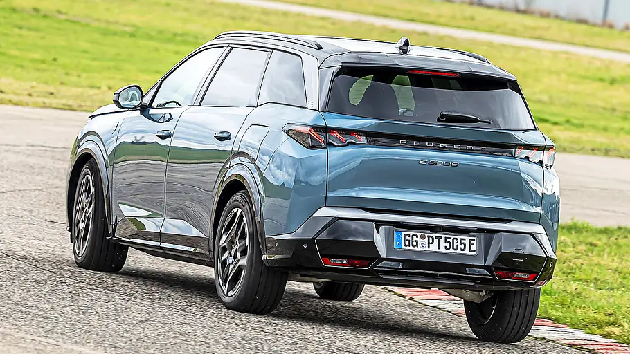 Blick von schräg hinten auf das fahrende Elektro-SUV Peugeot E-5008.