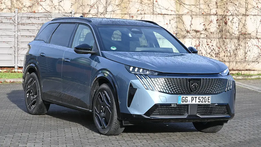 Der Peugeot E-5008 steht auf einem Parklplatz, von vorne rechts fotografiert.