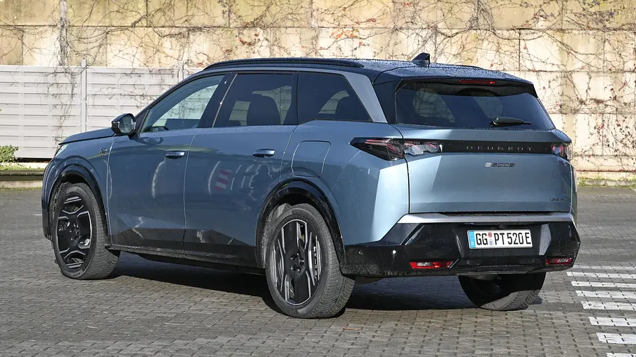 Der Peugeot E-5008 steht auf einem Parklplatz, von hinten links fotografiert.