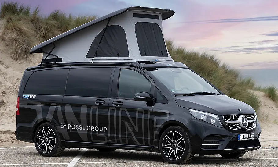 Die Außenaufnahme zeigt den geparkten Pössl Campstar (2025) schräg seitlich vor einem Strand mit ausgestelltem Aufstelldach.