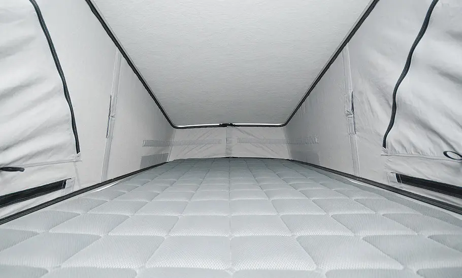 Die Innenaufnahme zeigt den Schlafplatz unterm Aufstelldach des Pössl Campstar (2025).