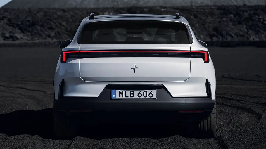 Polestar 4 SUV steht auf Sand, Ansicht des Fahrzeugs von hinten.
