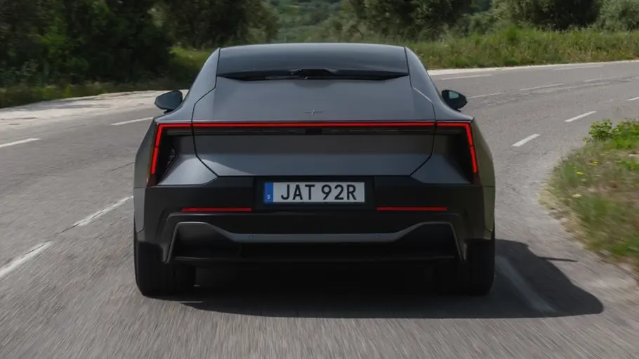 Polestar 5 fährt auf einer Landstraße, Ansicht von hinten.