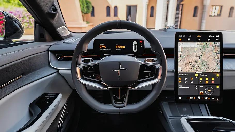 Das Cockpit des Polestar 5 Performance zeigt ein Lenkrad, digitale Instrumente und einen großen Hochkant-Touchscreen mit Kartenansicht.