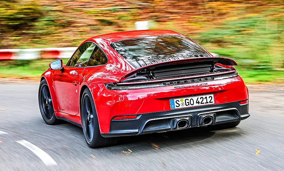 Porsche 911 Carrera 4 GTS T-Hybrid Blick von schräg hinten auf den fahrenden Porsche 911 Carrera 4 GTS T-Hybrid.