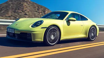 Blick von schräg vorne auf den fahrenden Porsche 911 Carrera S (2025). - Foto: Porsche