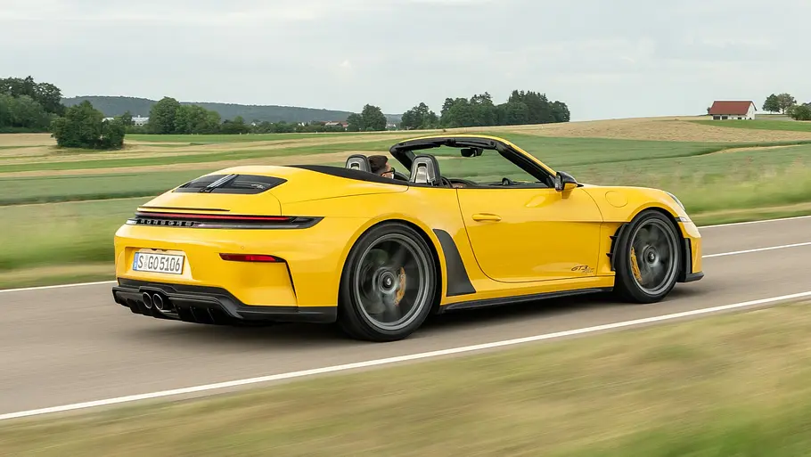 Porsche 911 GT3 S/C Der Porsche 911 GT3 S/C fährt mit offenem Dach auf einer Landstraße, von hinten rechts fotografiert.