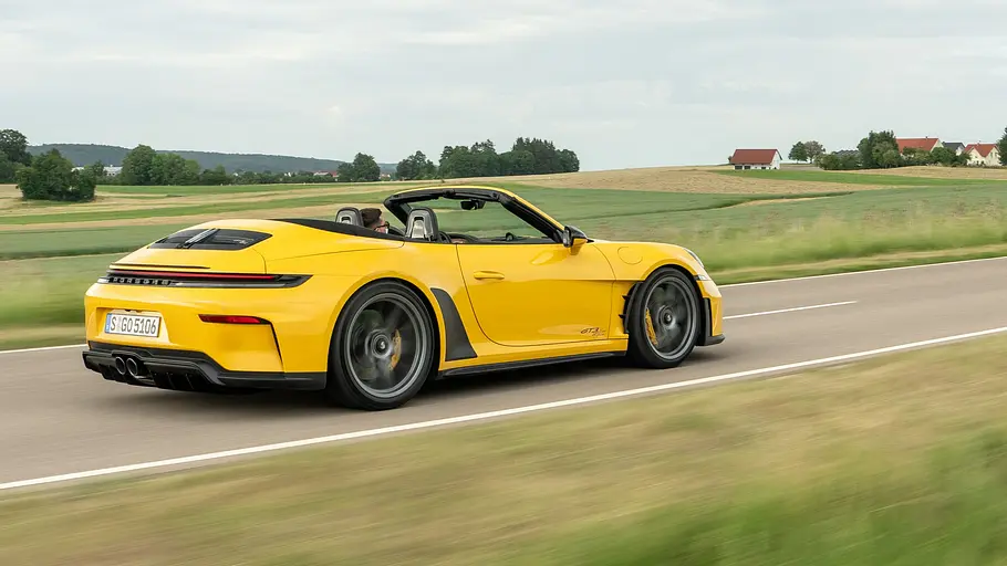 Porsche 911 GT3 S/C Der Porsche 911 GT3 S/C fährt mit offenem Dach auf einer Landstraße, von hinten rechts fotografiert.