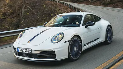 Der Porsche 911 T (2025) fahrend in einer Kurve, von schräg vorne links fotografiert. - Foto: Porsche