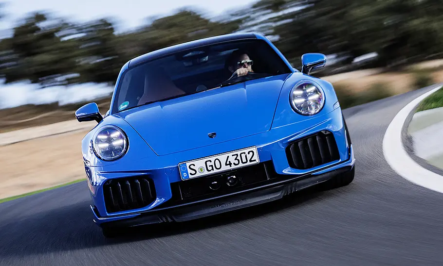 Der Porsche 911 Turbo S (2025) fährt über eine Rennstrecke, fotografiert von vorne.