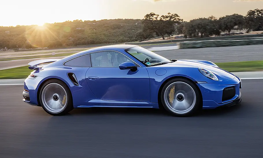 Der Porsche 911 Turbo S (2025) fährt über eine Rennstrecke, fotografiert von der Seite.