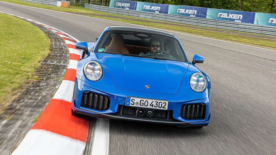 Der Porsche 911 Turbo S fährt auf dem Nürburgring, von vorne fotografiert.